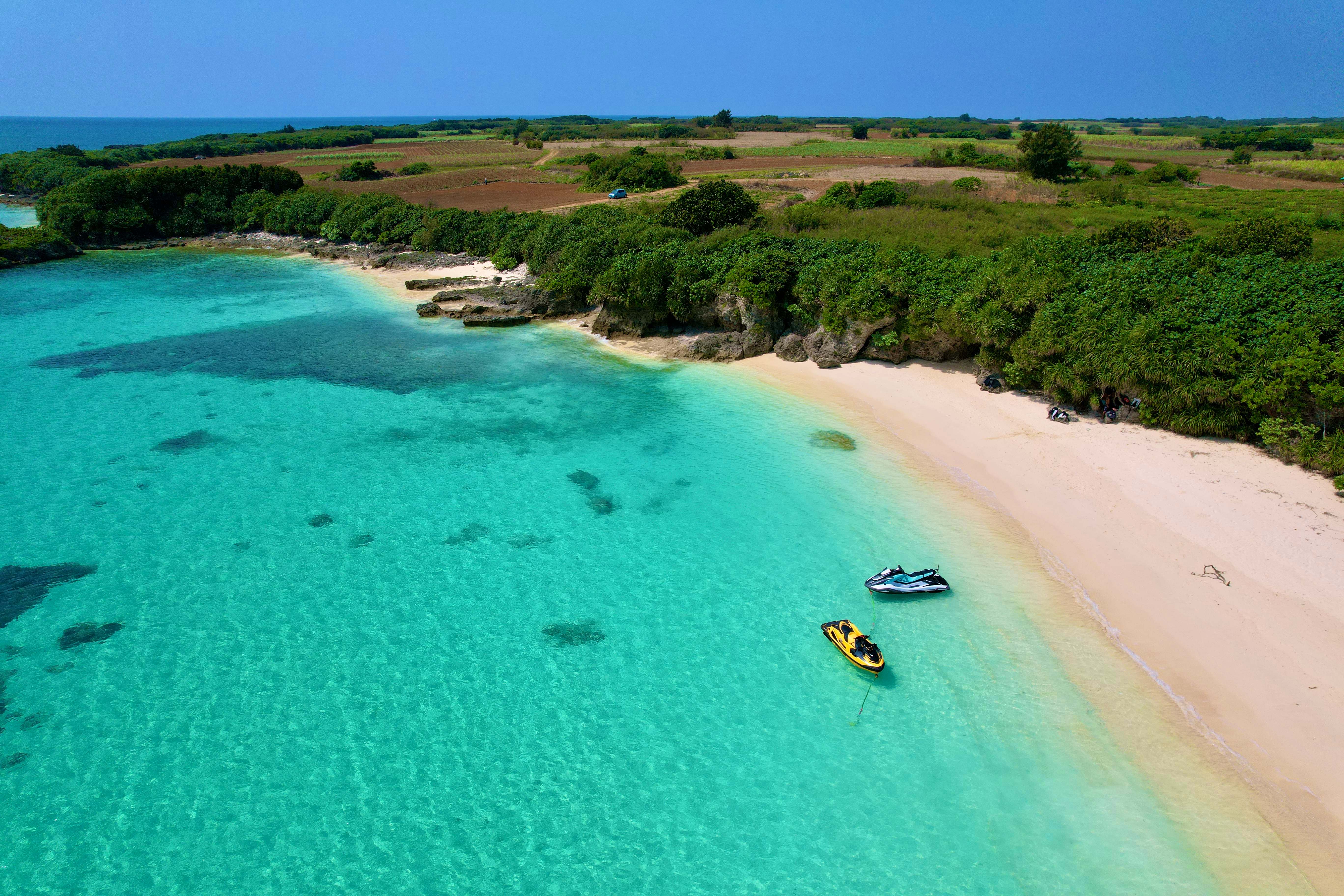 クリスタルブルーの海と白い砂浜 - ジェットスキーが浮かぶ宮古島の絶景ビーチ